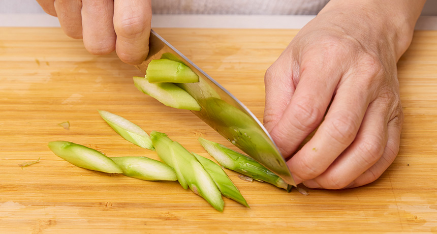 写真 鶏肉は一口大に切る。アスパラガスは根元を2cm切り落とし、さらに3cm皮をむく。はかまと穂先をとり、切り口の面積が広くなるよう3cmの斜め切りにする。
