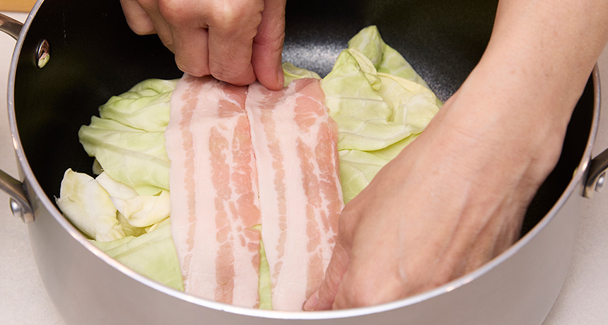 写真 鍋にキャベツと豚肉を交互に重ねてから、沸騰したお湯をたっぷりと入れ、10分煮る。